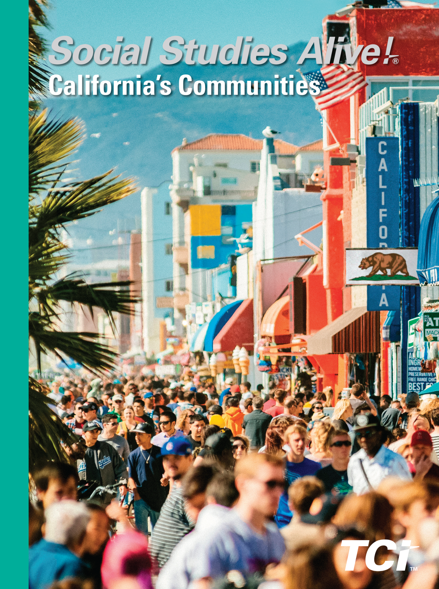 Crowded street in California with palm trees, colorful buildings, and mountains in the background.