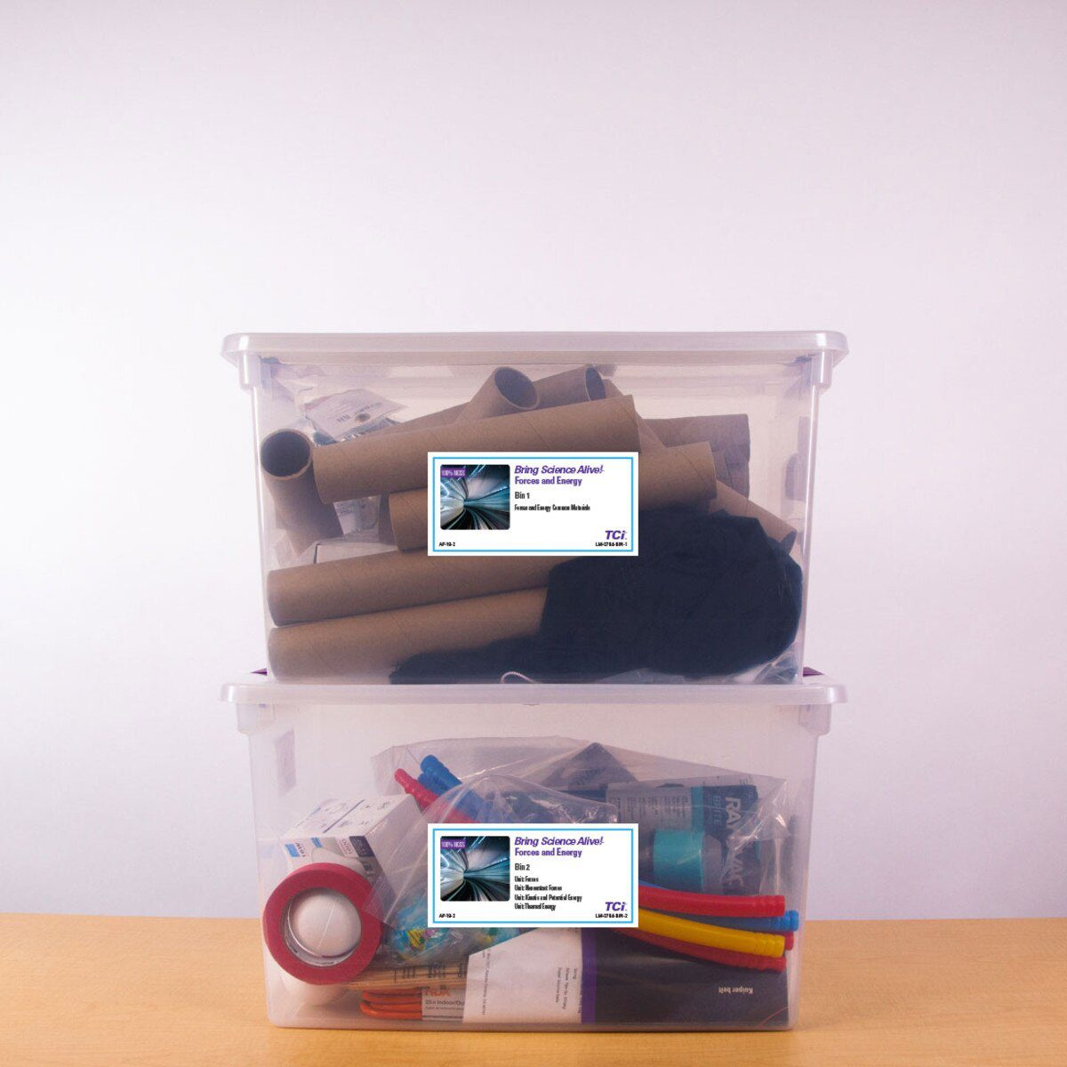 Two clear plastic bins stacked, containing various craft and science supplies, labeled Rising Science Ahead..