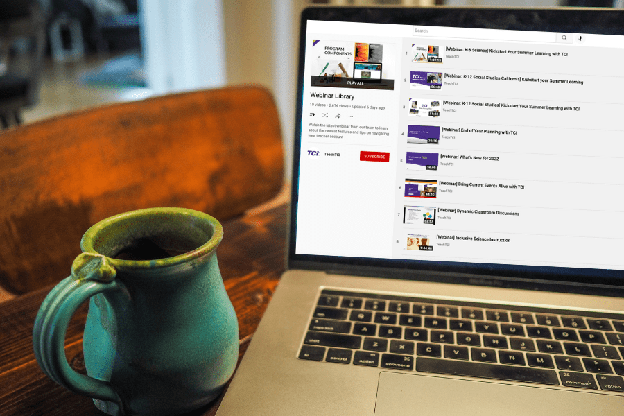 A teal mug sits next to a laptop showing a YouTube playlist titled Webinar Library..