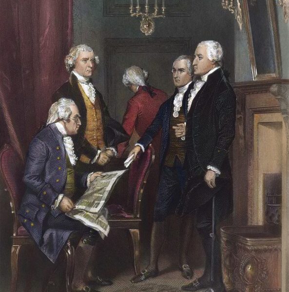 Four men in 18th-century attire discuss a document; one sits holding papers while others stand around him.