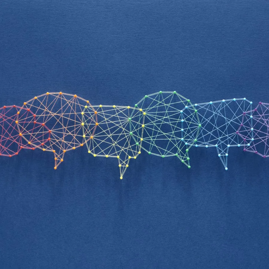 Five overlapping speech bubbles made of colorful string and pins on a blue background.
