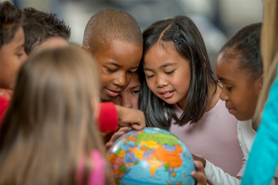 Elementary kids looking at a globe